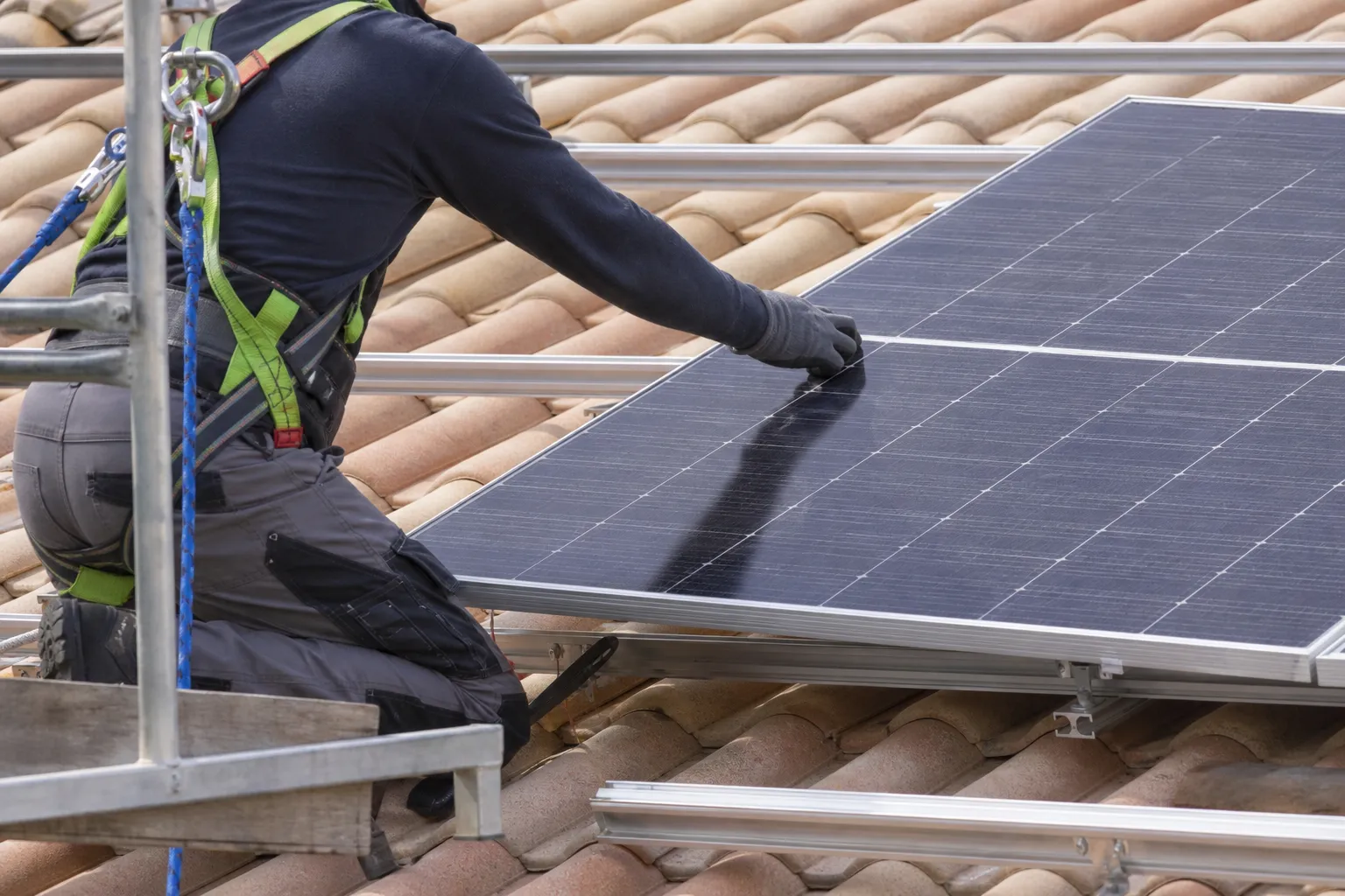 Notre installateur fixant un panneau solaire sur une toiture résidentielle